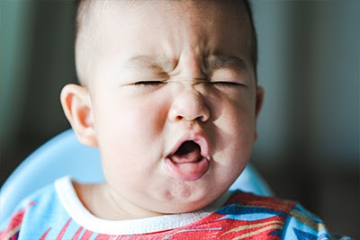 Closeup of a baby crying in pain from gasses