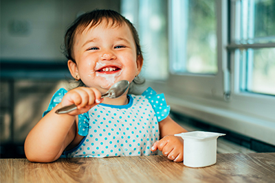 Baby girl enjoying yogurt