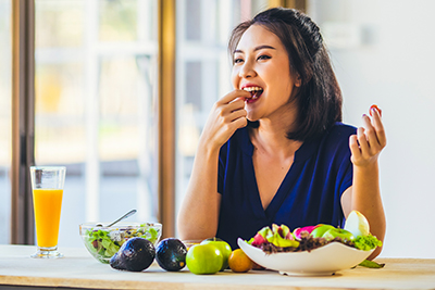 woman eating lots of types of fruit