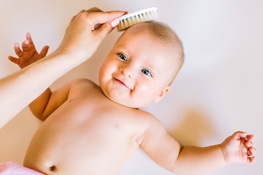 mother gently combing baby's hair